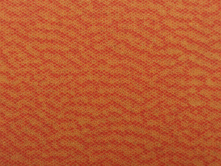 Red, orange fabric with spots.