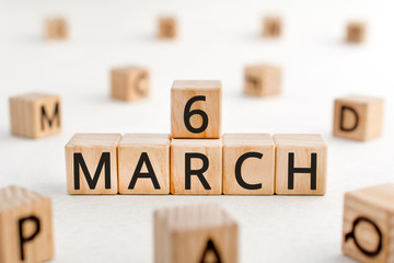 March 6 - from wooden blocks with letters, important date concept, white background random letters around