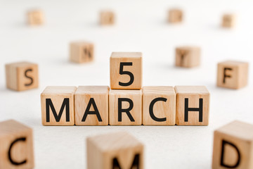 March 5 - from wooden blocks with letters, important date concept, white background random letters around