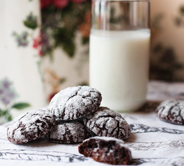Homemade chocolate cookies on the napkin and glass of milk.