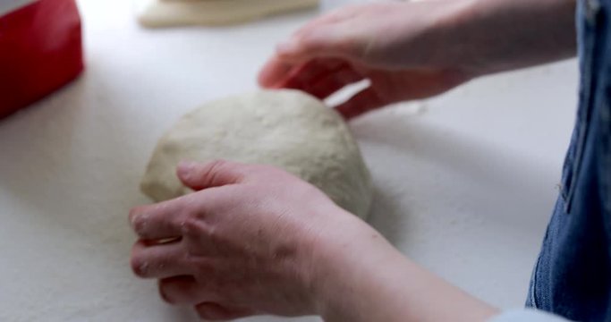 Close Up Of Woman Baking Bread Kneading Dough On Kitchen Worktop