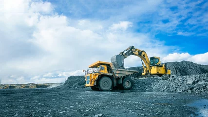 Fotobehang Vrachtwagen Work of trucks and the excavator in an open pit  © evgenii_v