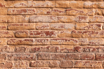 Retro grunge brick wall. Red brick wall with helmets of old, faded paint.