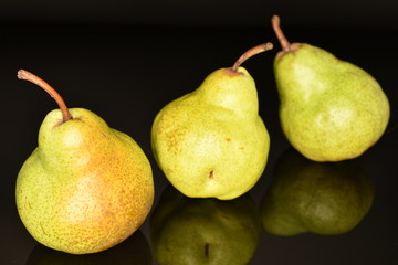 Fototapeta na wymiar Juicy ripe, sweet, organic green pears, close-up, on a black background.
