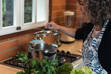woman cooking holding lid