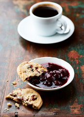 Cranberry cookies with jam on rustic wooden background. Close up.