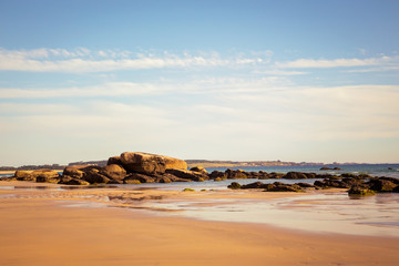 Low tide on a Galicia beach with rocks in the background