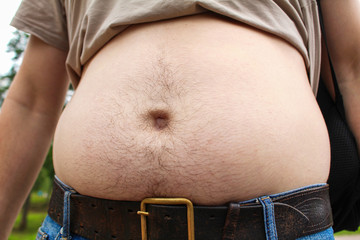 Thick hairy belly of a man close-up outdoor