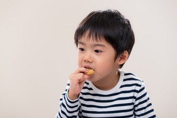 Kid boy eat cookie on white background