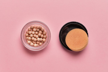 Cosmetic powder in the form of balls on a pink background. Top view.