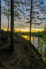 View from a rocky cliff on a sunset over small lake in the forest