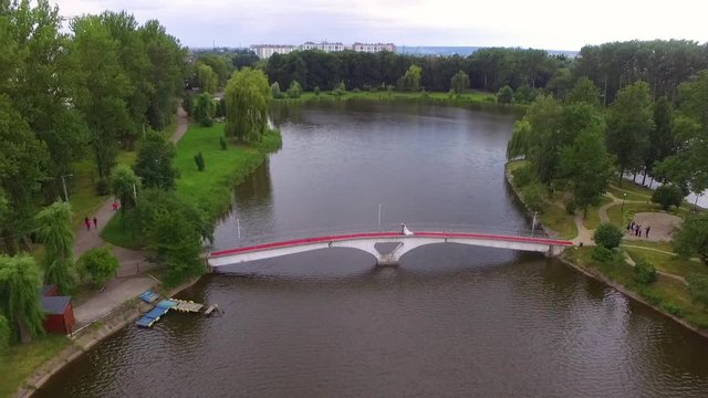 Drone flight over the bridge and the island on which stands a happy free couple