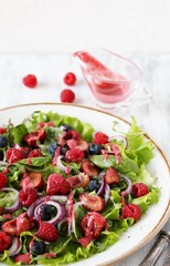 Salad with berries-raspberry, blueberry, sweet cherry. Dressed with raspberry vinaigrette. Soft focus. copy space