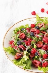 Salad with berries-raspberry, blueberry, sweet cherry. Dressed with raspberry vinaigrette. Soft focus. copy space