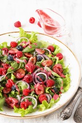 Salad with berries-raspberry, blueberry, sweet cherry. Dressed with raspberry vinaigrette. Soft focus. copy space