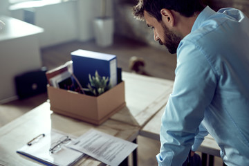 Male entrepreneur feeling sad about losing his job in the office.
