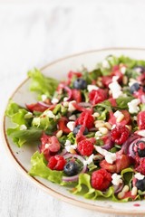 Salad with berries-raspberry, blueberry, sweet cherry. Dressed with raspberry vinaigrette. Soft focus. copy space