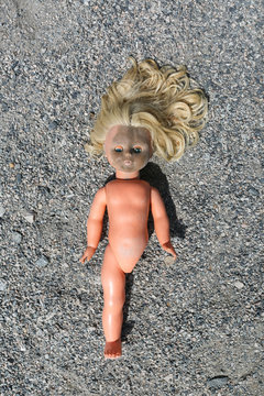 children's dirty doll orphan without legs lonely on the ground
