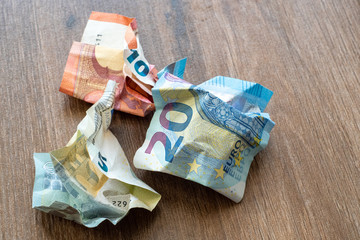 Crumpled euro money on a wooden background. Money in the period of inflation.