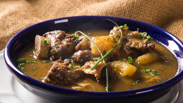 Slide shot rustic Stew meat with manioc called Vaca atolada in Brazil with smoke.
