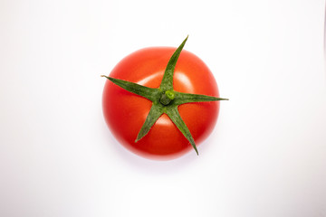 Close up view of tomato isolated on a white background with water drops on surface green stem top side. Space for copy