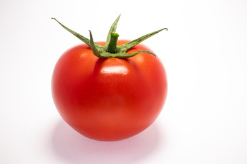 Close up view of tomato isolated on a white background with green stem. No people. Space for copy.