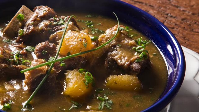 Slide shot rustic Stew meat with manioc called Vaca atolada in Brazil with smoke.