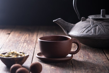 Traditional asian tea ceremony, the process of brewing tea, warm soft light, a dark background.