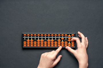 Сhild counting on soroban abacus. Black background with copy space. Concept education, school...