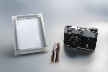 Vintage camera, film and stylish empty photo frame on a gray gradient background. Empty space. Layout. Stylized stock photos.