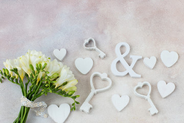 Fototapeta na wymiar bouquet of white freesia and decor hearts and keys 