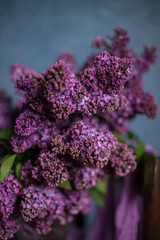 Bouquet of lilac on a dark background on a chair