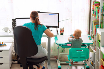 Mother with kid working from home during quarantine. Stay at home, work from home concept during...
