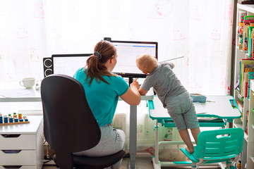 Obraz premium Mother with kid working from home during quarantine. Stay at home, work from home concept during coronavirus pandemic
