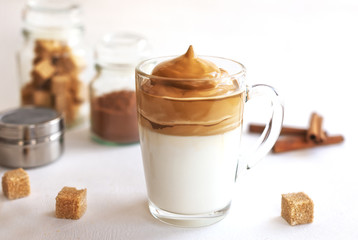 Cold Dalgon coffee in a glass on a white background. A trendy drink made from whipped instant coffee and milk. Close up.