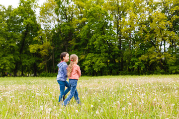 Fototapeta premium Two adorable girls dancing on the meadow