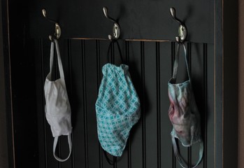 Masks hang ready to use. Part of the leaving the house checklist now includes remembering your mask. Many of us now have one hanging in out car or near the front door.