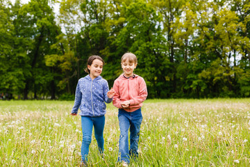 Fototapeta premium Two sisters hug one another outdoors, happy family