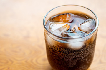 Close up Glass filled with carbonated cola soft drink with ice cubes. selective focus