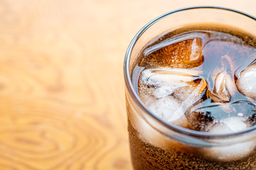 Close up Glass filled with carbonated cola soft drink with ice cubes. selective focus