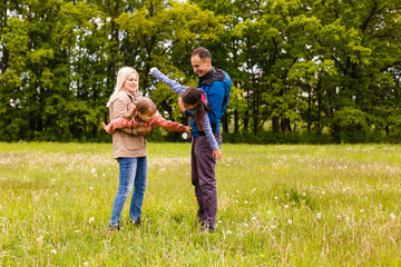 Fototapeta premium young familiy are walking through a green field