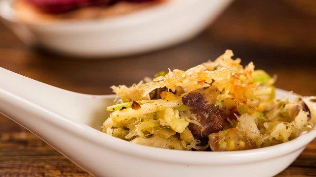 Slide shot Shredded cod with scrambled eggs, banana puree and crispy potato in a spoon. Taste gastronomy finger food with smoke