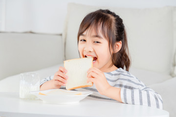 Asian little girl eating breakfast at home