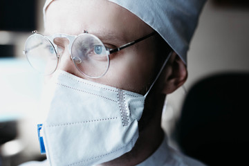 Closeup portrait of a heroic dramatic doctor in masked glasses and uniform.