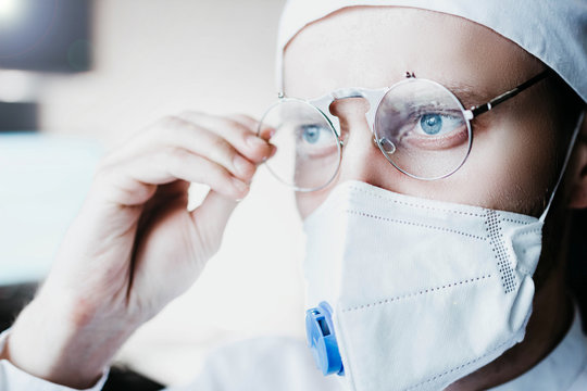 Closeup portrait of a heroic dramatic doctor in masked glasses and uniform.