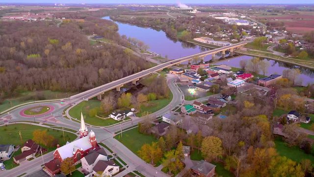 Beautiful new bridge over tranquil river in small town America, morning twilight aerial view.