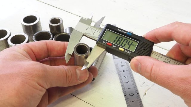 Engineer work. Measurement of the metal part of driving chain with a caliper.
