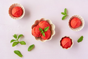 Homemade strawberry, red berry  ice cream , sorbet with  mint leaves on pastel pink background. Top view