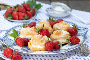 Windbeutel und Erdbeeren auf einem Teller