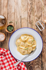 Traditional italian ravioli with rosemary and parmesan served onon an enamel plates. Italian pasta.